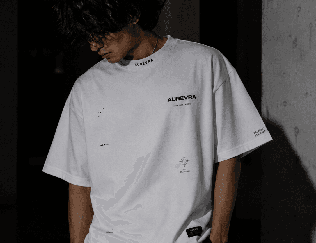 AUREVRA white oversized tee with small chest graphics and a dropped shoulder